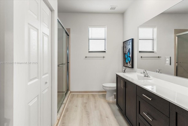 full bathroom with a closet, plenty of natural light, wood finished floors, and a shower stall