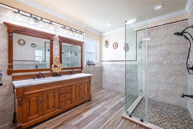 full bath with tile walls, a shower stall, and a sink