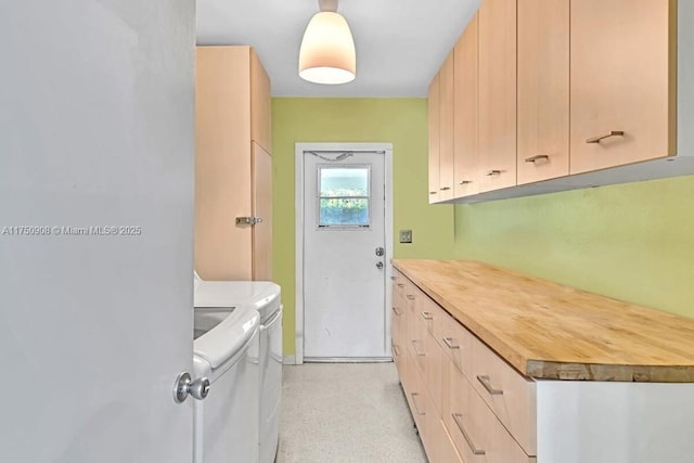 kitchen with light brown cabinetry, butcher block countertops, and washing machine and dryer