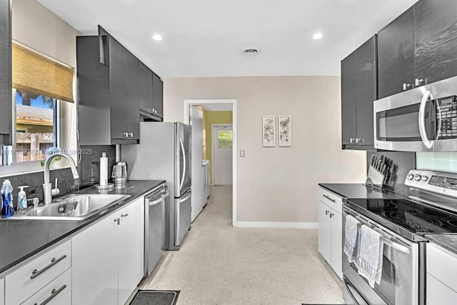 kitchen with tasteful backsplash, dark countertops, visible vents, appliances with stainless steel finishes, and a sink