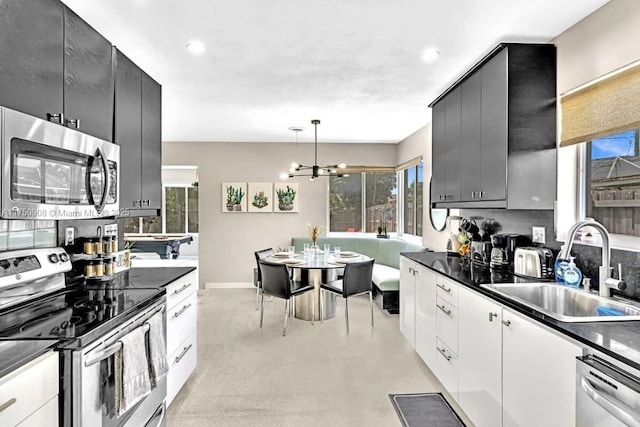 kitchen featuring dark countertops, appliances with stainless steel finishes, and a sink