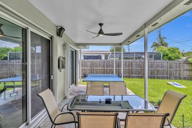 sunroom / solarium featuring a ceiling fan