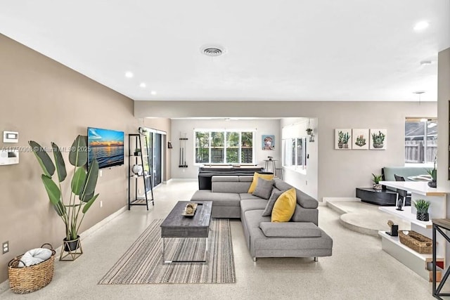 living room featuring baseboards, visible vents, and recessed lighting