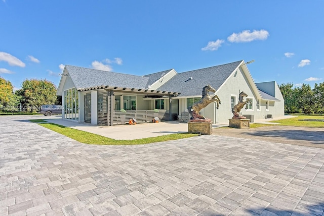 rear view of house with a patio and stucco siding