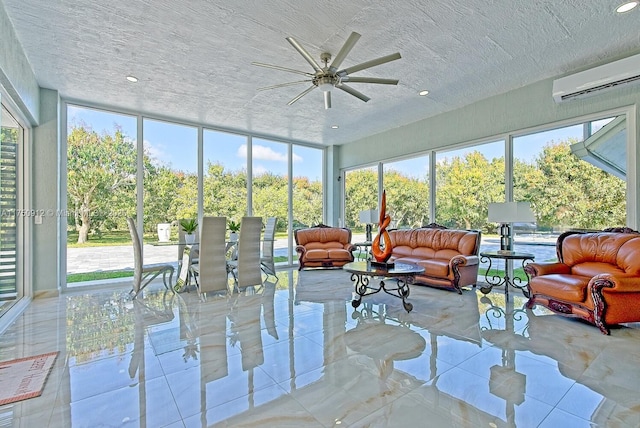 sunroom with plenty of natural light, a wall mounted air conditioner, and a ceiling fan