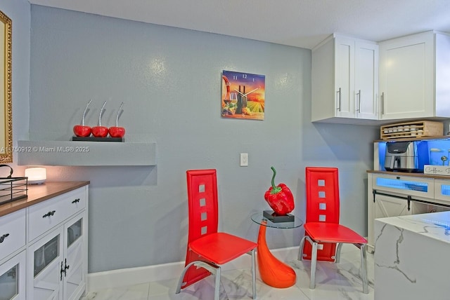 interior space featuring baseboards and white cabinets