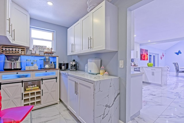 kitchen with marble finish floor, recessed lighting, white cabinetry, light stone countertops, and a peninsula