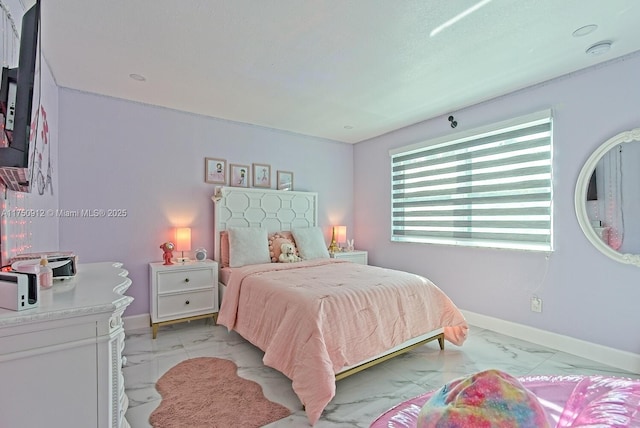 bedroom featuring marble finish floor and baseboards