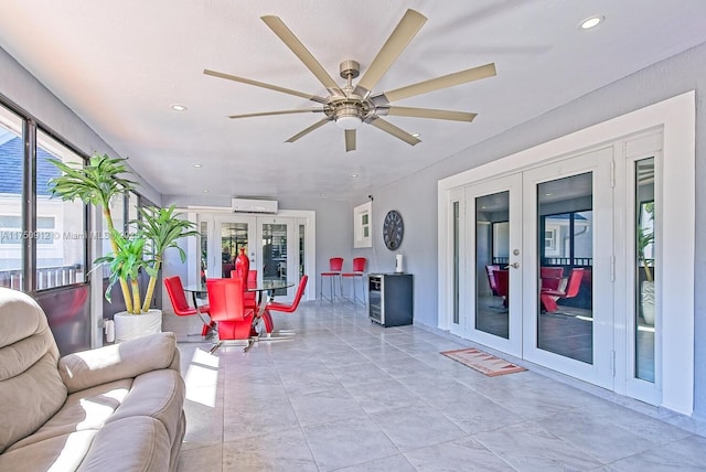 sunroom / solarium with french doors, a wall mounted air conditioner, and a ceiling fan