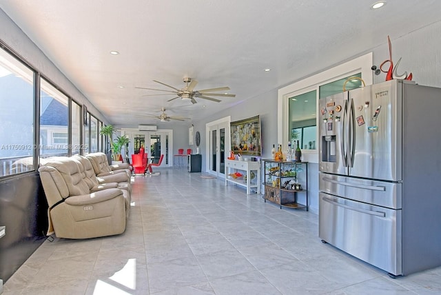 sunroom with a ceiling fan, a wealth of natural light, and a wall unit AC