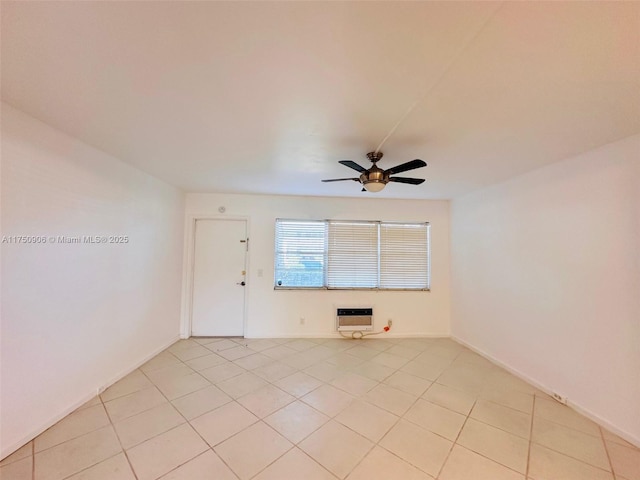 spare room with heating unit, baseboards, a ceiling fan, and light tile patterned flooring