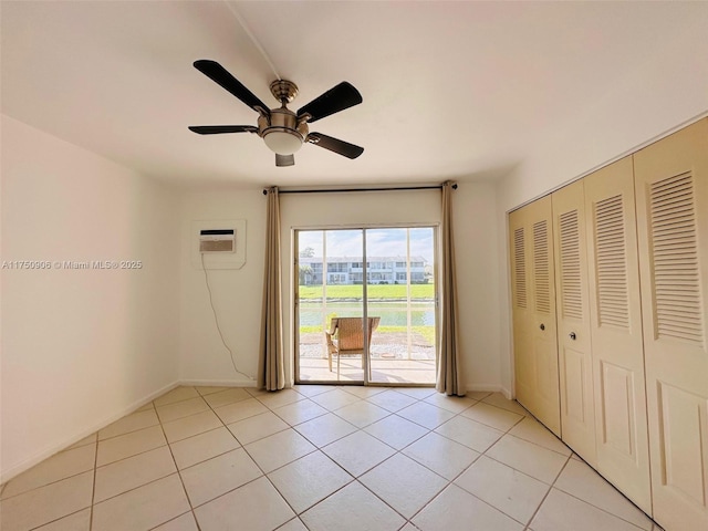 unfurnished room featuring a ceiling fan, a wall mounted air conditioner, and light tile patterned floors