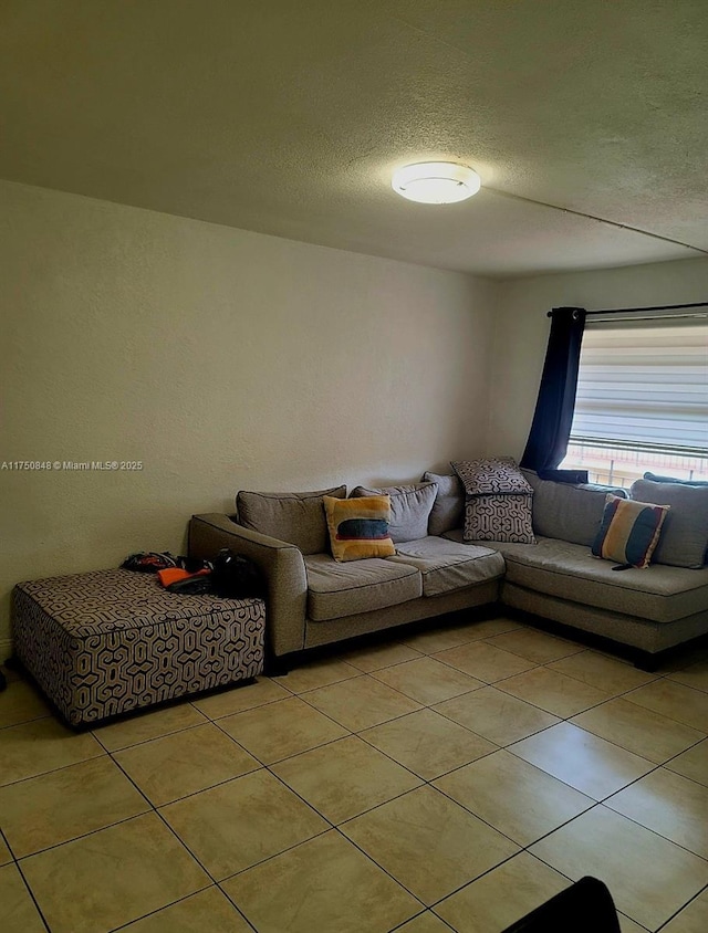 living area featuring a textured ceiling and light tile patterned floors