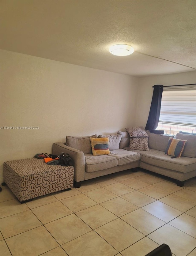 living area featuring a textured ceiling and light tile patterned floors