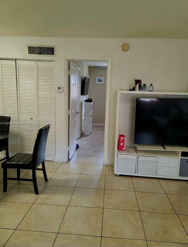 interior space featuring light tile patterned floors, baseboards, and visible vents