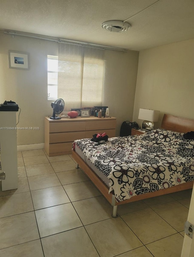 bedroom featuring baseboards and light tile patterned floors