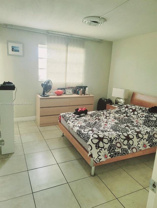 bedroom featuring baseboards and light tile patterned flooring