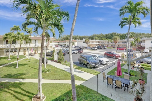 view of community featuring uncovered parking, a residential view, and a lawn