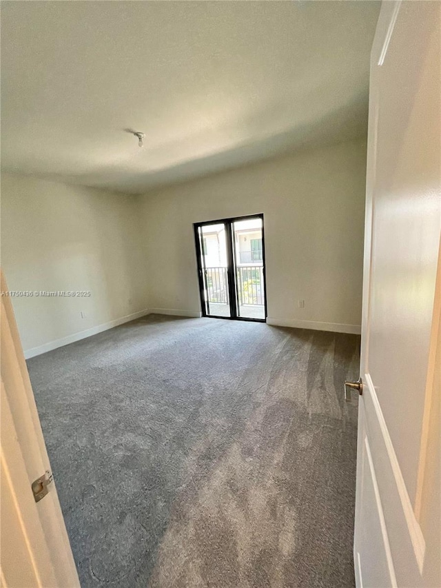 carpeted spare room featuring baseboards