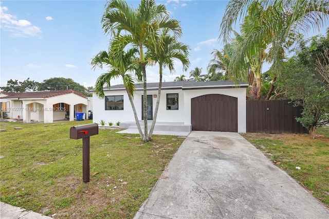 view of front of house featuring concrete driveway, stucco siding, an attached garage, fence, and a front yard