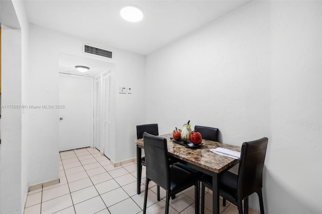 dining space with light tile patterned floors, visible vents, and baseboards