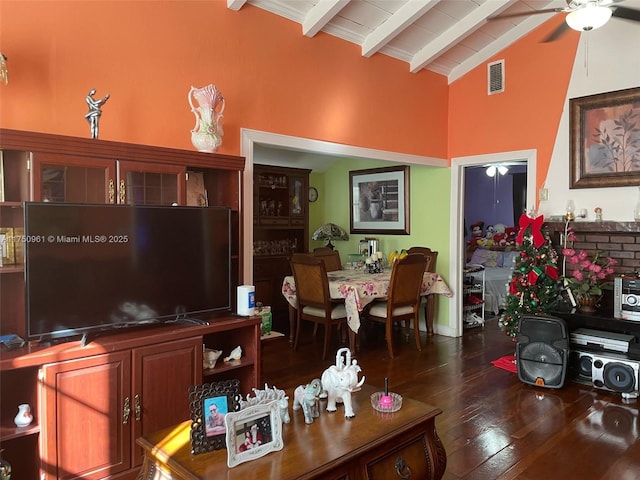 living area featuring lofted ceiling with beams, ceiling fan, dark wood-style floors, and visible vents