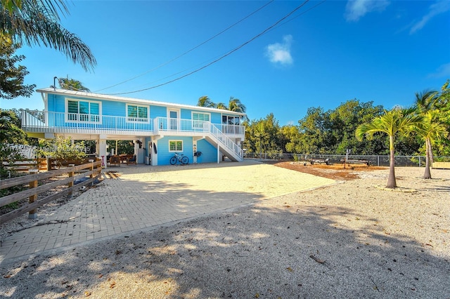 back of house featuring a fenced front yard, a porch, and decorative driveway