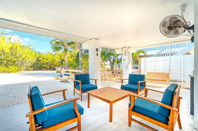 view of patio featuring ceiling fan, fence, and outdoor lounge area