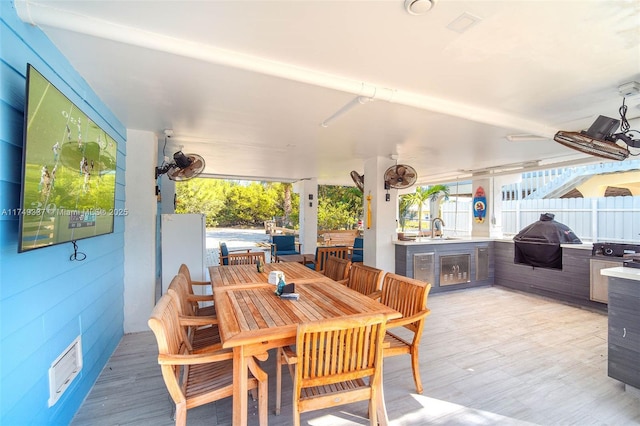 view of patio / terrace with ceiling fan, grilling area, fence, a sink, and outdoor dining space