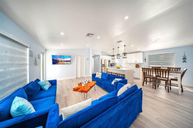 living area featuring light wood finished floors, visible vents, and recessed lighting