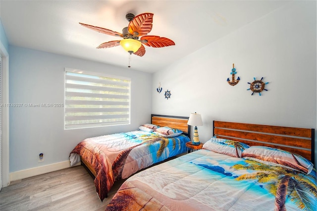 bedroom featuring baseboards, a ceiling fan, and light wood-style floors