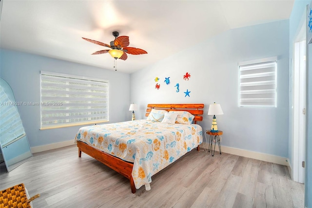 bedroom featuring light wood-type flooring, baseboards, and a ceiling fan