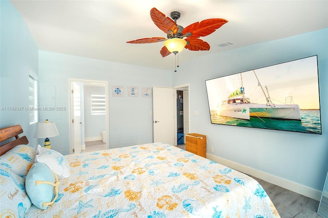 bedroom with baseboards, visible vents, a ceiling fan, connected bathroom, and wood finished floors