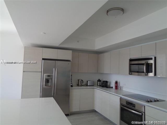 kitchen with light countertops, appliances with stainless steel finishes, and modern cabinets