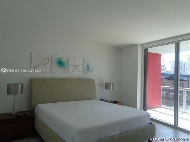 bedroom featuring light wood-type flooring and expansive windows