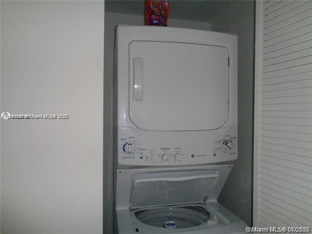 clothes washing area featuring laundry area and stacked washing maching and dryer