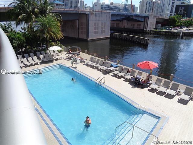 community pool with a water view, a view of city, and a patio