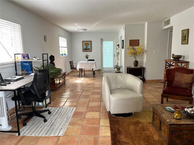 office area with light tile patterned floors, visible vents, and baseboards