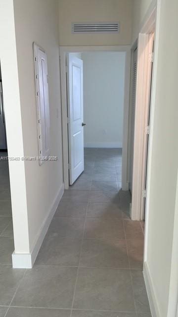 hallway featuring tile patterned flooring, visible vents, and baseboards