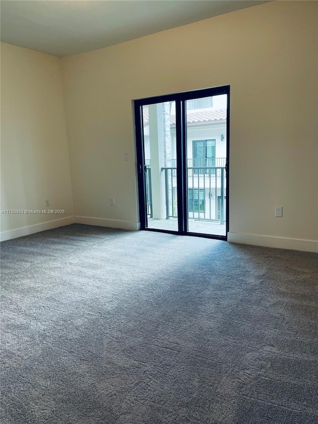 carpeted spare room featuring baseboards