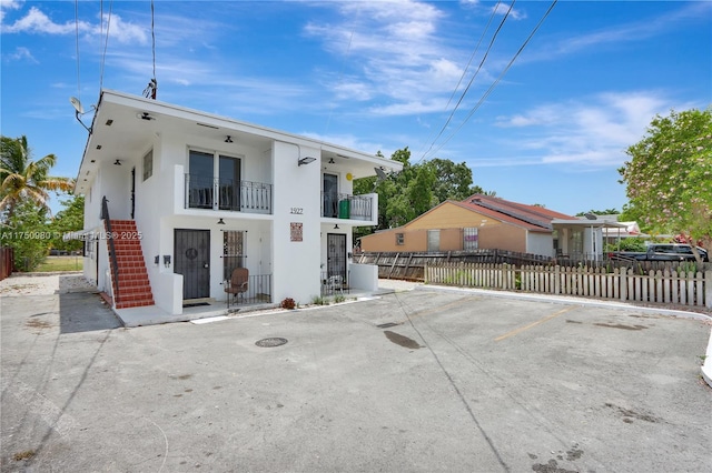 view of front of home featuring uncovered parking, a fenced front yard, and stucco siding