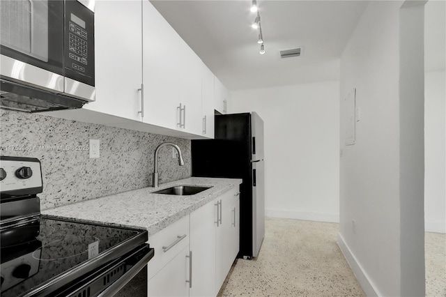 kitchen featuring stainless steel microwave, range with electric cooktop, a sink, and white cabinets