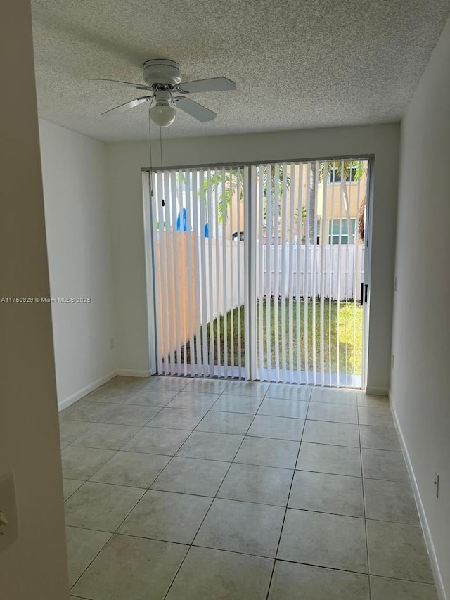 unfurnished room featuring light tile patterned floors, a ceiling fan, baseboards, and a textured ceiling