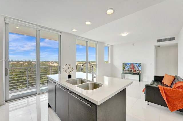 kitchen with visible vents, open floor plan, a wall of windows, a sink, and light tile patterned flooring