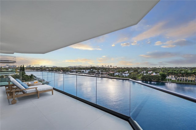 balcony featuring a water view and a city view