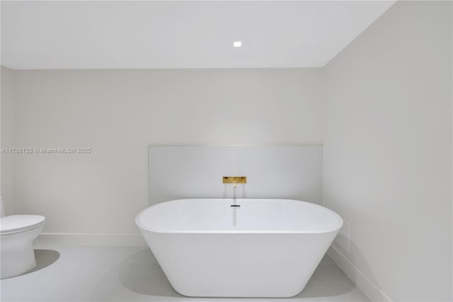 5500 Collins Ave Unit 802, Miami Beach, FL 33140 - bathroom with baseboards, a freestanding tub, tile patterned flooring, and toilet