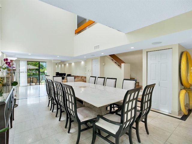 dining room featuring recessed lighting, visible vents, a towering ceiling, stairway, and light tile patterned flooring