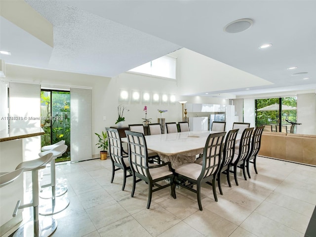 dining space featuring lofted ceiling, a textured ceiling, and recessed lighting