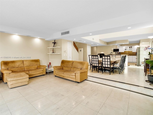 living area featuring light tile patterned floors, visible vents, and recessed lighting