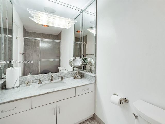 full bath with a stall shower, tile patterned flooring, vanity, and toilet